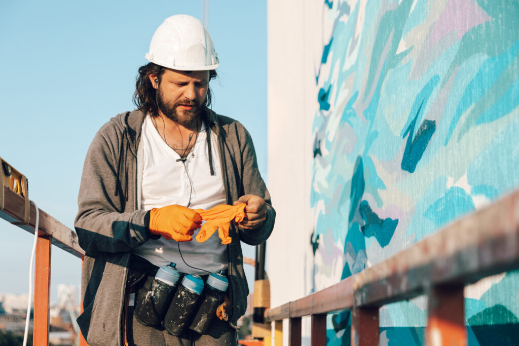 contractor-artist-high-altitude-building-cradle-puts-gloves-prepares-carry-out-facade-painting